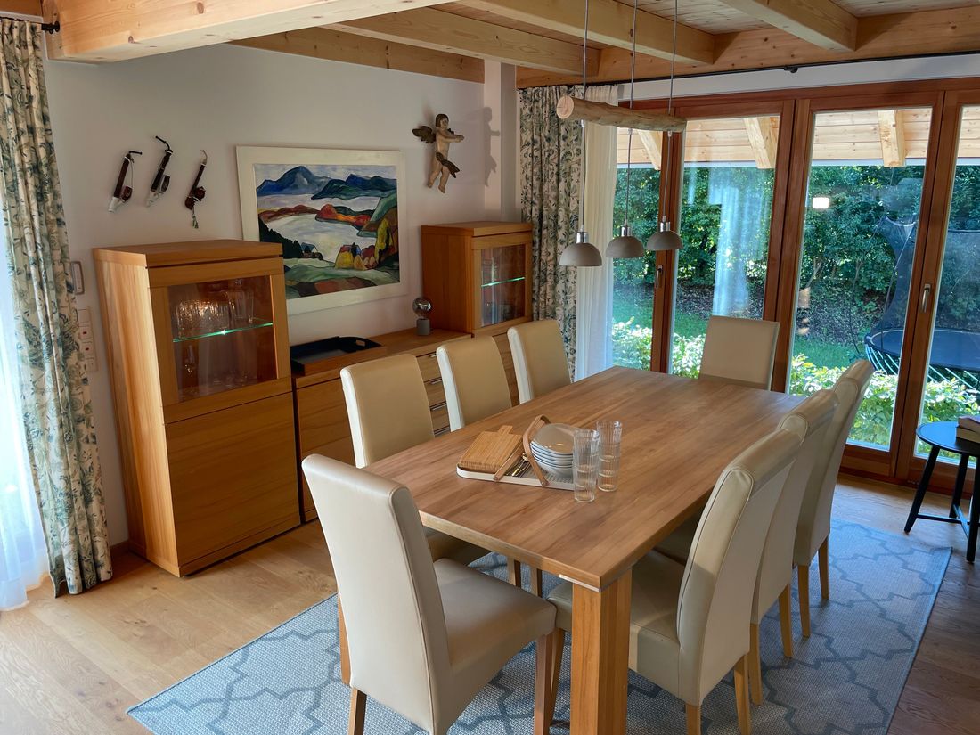 Esszimmer mit Holztisch für 8 Personen und Blick auf den Garten